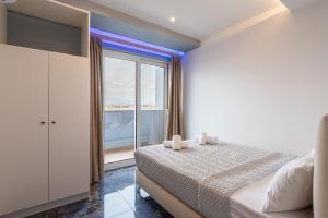 a bedroom with a bed and a large window at Poseidon 5 in Paralia Katerinis
