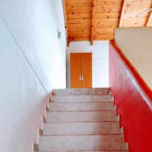 a staircase in a building with a wooden door at Complejo Enjoy in Las Grutas +1 photo