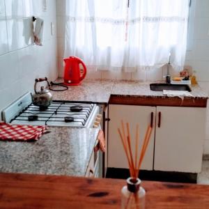 a kitchen with a stove and a counter top at Complejo Enjoy in Las Grutas