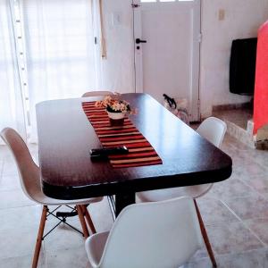 a black table with white chairs and a plant on it at Complejo Enjoy in Las Grutas