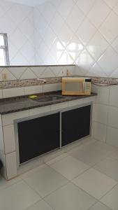 a kitchen with a counter with a microwave on it at Suite Brisa 201 in Pedra de Guaratiba