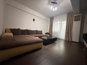 a living room with a couch and a window at Green Paradise in Curtea de Argeş