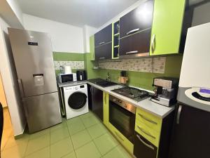 a kitchen with a refrigerator and a washer and dryer at Green Paradise in Curtea de Argeş +15 photos