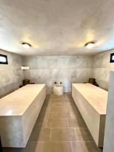 a room with two beds in a room with tiles at Weedan Hotel & Spa Marrakech in Oulad Snaguia