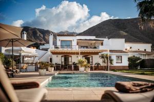 a house with a swimming pool in front of a house at Boutique Hideaway Cortijo El Sarmiento - Adults Only in Mojácar
