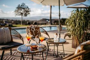 a patio with two tables and chairs with drinks at Boutique Hideaway Cortijo El Sarmiento - Adults Only in Mojácar