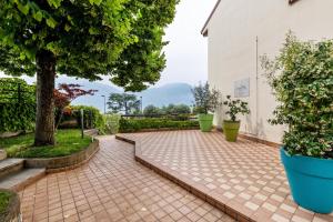 a brick courtyard with a tree and a white building at Casa Tuly 1 in Brenzone sul Garda
