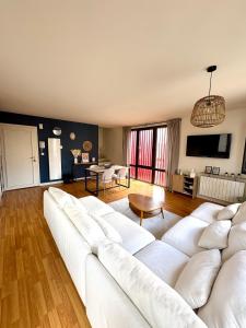 a living room with a white couch and a table at Le Rubis - hyper centre et proche plage in Dinard