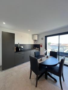 a kitchen and dining room with a table and chairs at Les Appartements chez Hanene in Le Grau-du-Roi