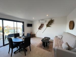a living room with a table and a couch at Les Appartements chez Hanene in Le Grau-du-Roi