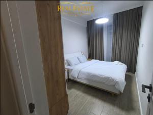 a small bedroom with a bed with white sheets at Verin Apart Hotel in Aghk'ilisa