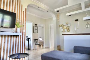a living room with a blue couch and a tv at Adriana's Summer House in Kassiopi