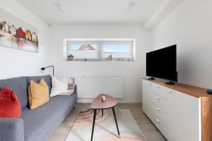 a living room with a couch and a flat screen tv at Ferienwohnung Emilia 2 in Garding