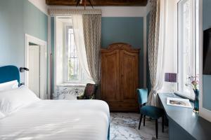 a bedroom with a bed and a desk and a window at Nus Hotel Poerio in Rome