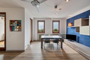 a dining room with a table and a blue wall at Casa Tuly in Brenzone sul Garda