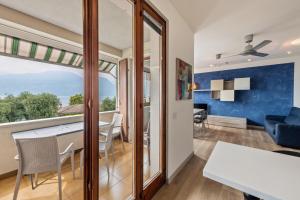 a dining room and living room with a large window at Casa Tuly in Brenzone sul Garda