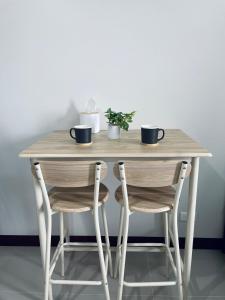 a wooden table with two chairs and two cups on it at Saekyung Marigondon in Suba
