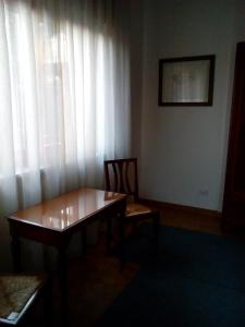 una camera con tavolo e finestra con tende bianche di Villa Osmanthus a Vicenza