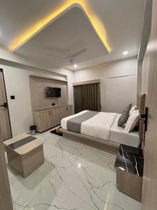 ein Schlafzimmer mit einem Bett und einem Fernseher an der Wand in der Unterkunft Hotel Pine Ville in Ahmedabad + 10 Fotos
