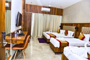 a hotel room with two beds and a desk at Prince Palace And Banquet in Pāndharkawada
