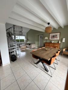 a large living room with a table and a staircase at Maison proche Hossegor in Tosse