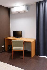 a desk with a computer and a chair in a room at Hostal Mediterranea in Madrid