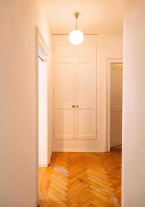 an empty room with a white door and a wooden floor at Flat 12-min walk to Bern station in Bern +1 photo