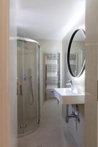 a bathroom with a shower and a sink and a mirror at Sunset Cove by halu! - Spacious 4-bedroom Villa in Neos Marmaras +47 photos