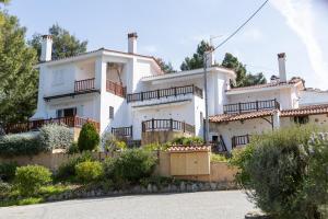a white house with balconies on the side of it at Sunset Cove by halu! - Spacious 4-bedroom Villa in Neos Marmaras