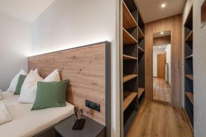 a room with a bed and a wall with shelves at Wohnung Morgenduft Schnalserhof in Laces