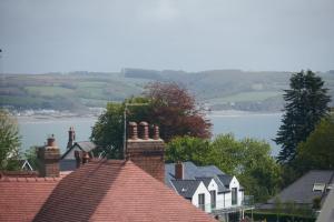 a roofs of houses with a view of a lake at Footprints - gorgeous coastal apartment with sea views in Saundersfoot