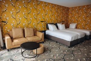 a hotel room with two beds and a chair at Van der Valk Hotel Harderwijk op de Veluwe in Harderwijk +67 photos