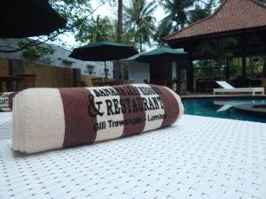a rolled up towel sitting next to a swimming pool at Banana Leaf Resort in Gili Trawangan
