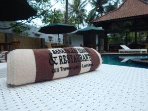 a rolled up towel sitting next to a swimming pool at Banana Leaf Resort in Gili Trawangan