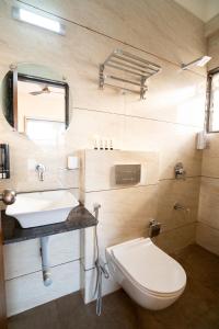 a bathroom with a white toilet and a sink at 46 Elite Enclave in Nashik +46 photos