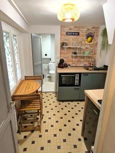 a kitchen with a table and a stove and a sink at Maison de la Liberté - Petite maison à 4 étages in Nyons