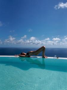 a woman laying on the edge of a swimming pool at Nya Uluwatu in Uluwatu