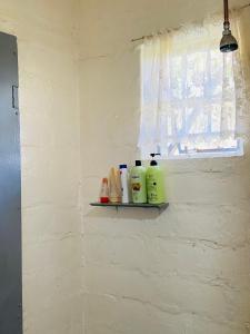 a shelf on a wall with bottles of detergent at Mountain View Escape in Mbabane