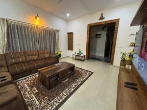 a living room with a couch and a coffee table at Satgiri Nest House in Chikmagalūr