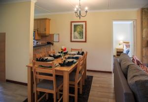 a dining room and living room with a table and chairs at Gooderson Leisure Riverbend Chalets Self Catering in Drakensberg Garden