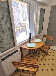a table and chairs in a room with a window at Maison de la Liberté - Petite maison à 4 étages in Nyons