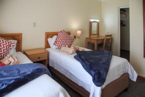 a bedroom with two beds and a mirror at Gooderson Leisure Riverbend Chalets Self Catering in Drakensberg Garden +29 photos
