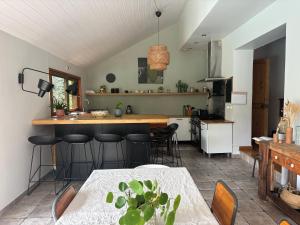 a kitchen with a table and some bar stools at Exceptional house with a pool in Jarrie