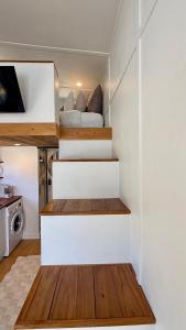 a tiny house with a staircase in a room at Grace & Rose in Gibbston