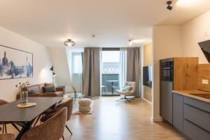 a kitchen and living room with a table and chairs at AlegraStay Apartments - Dresden City in Dresden