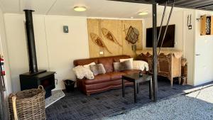 a living room with a couch and a wood stove at Grace & Rose in Gibbston