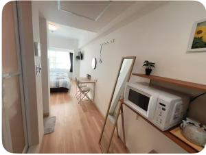 a living room with a microwave on a counter at Lucky民泊 in Osaka
