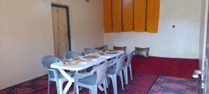 a dining room with a table and chairs with food on it at Diafat ISSIRIDEN in Tazrouft +16 photos