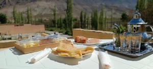 a table with a plate of food and a tray of fries at Diafat ISSIRIDEN in Tazrouft