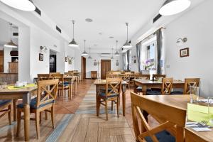 a dining room with wooden tables and chairs at Resort Rybníček in Blatnice
